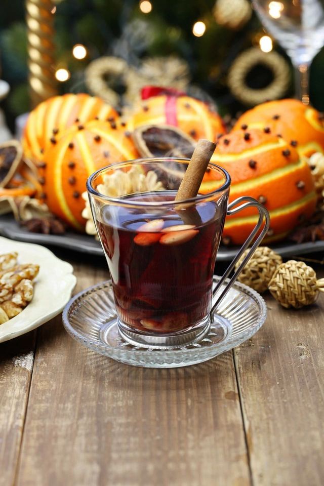 A glass of spiced mulled wine with cinnamon stick and orange slices.